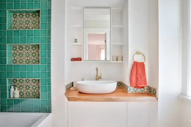 Albany, NY bathroom renovation with green patterned tile niches, white vessel sink and butcher block vanity top